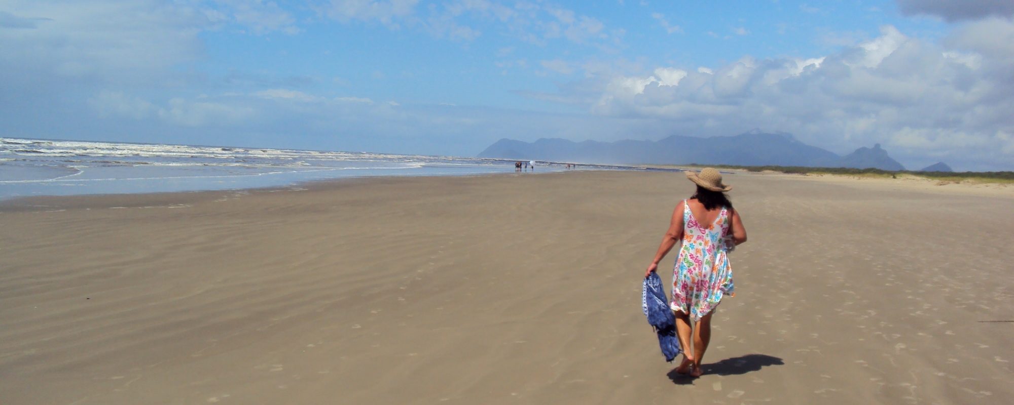 mulher caminhando em praia deserta