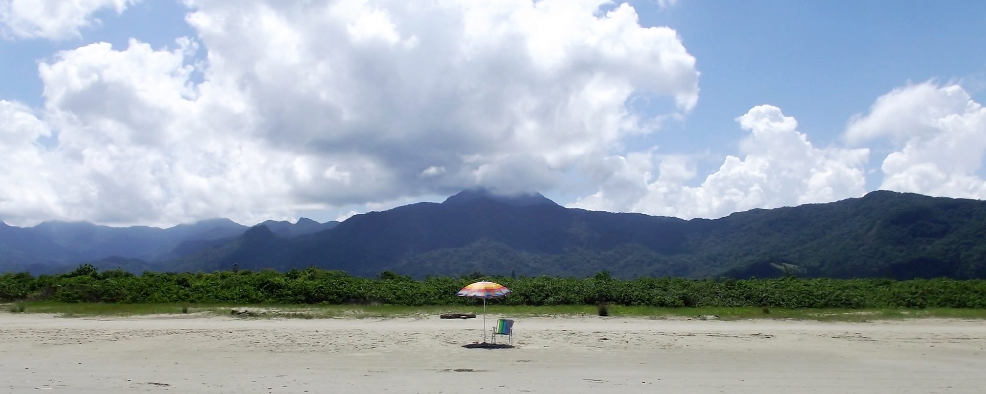 cadeira e guarda-sol em uma praia deserta